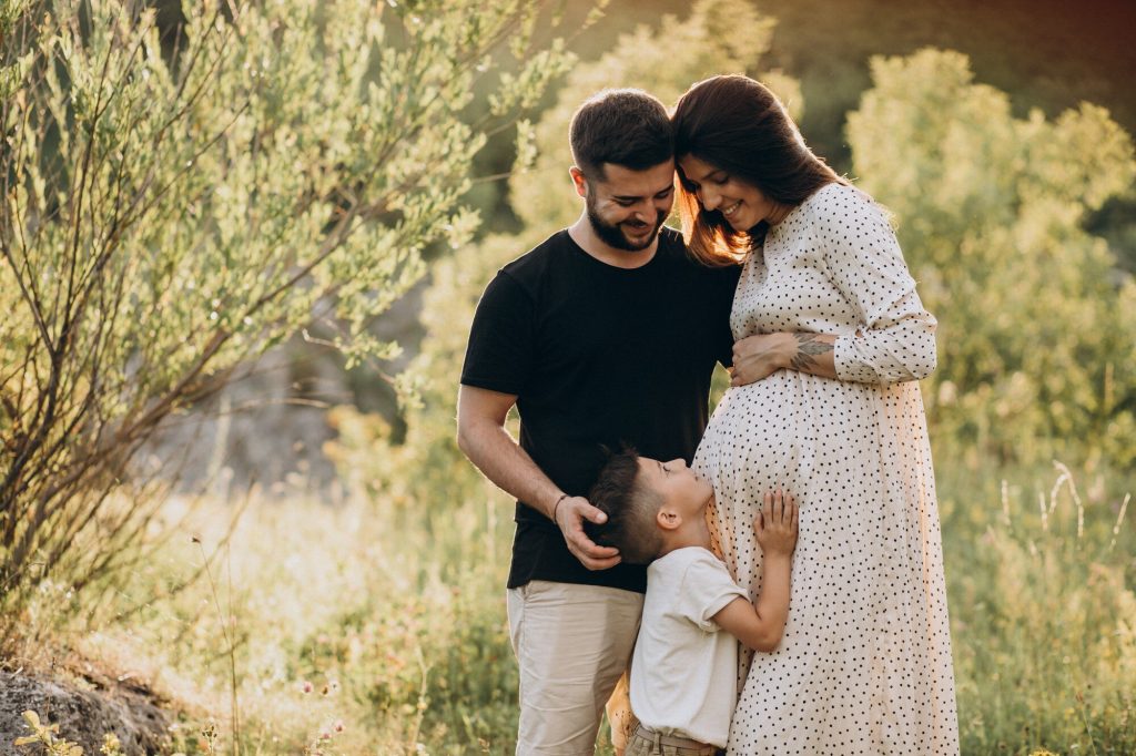 Une photo de grossesse en famille permet d'avoir des souvenirs avec la fratrie.