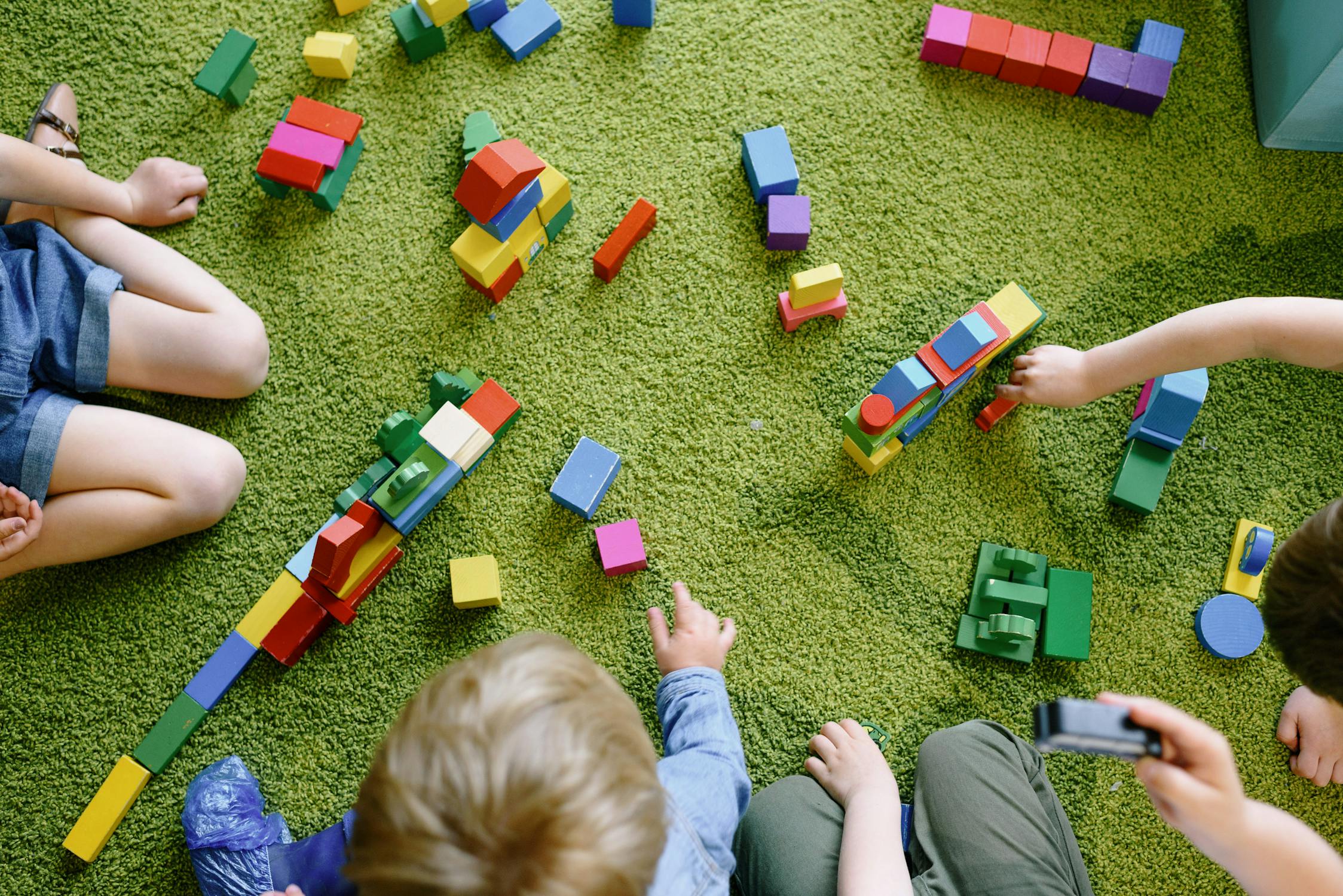 Les enfants de 4 ans peuvent jouer avec des jouets de construction en bois.